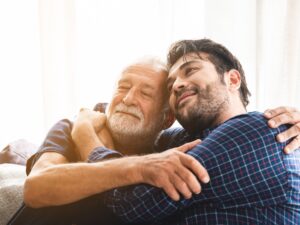 Son hugging his elderly father.